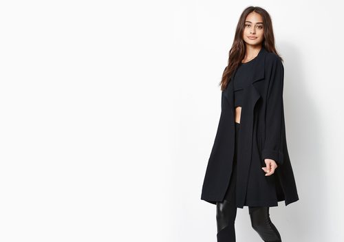 Modelo con conjunto negro de top, pantalón de cuero y abrigo de Kendall y Kylie Jenner para PacSun