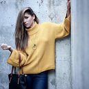 Mariam Hernández con jersey amarillo y bolso negro de Paula Franco