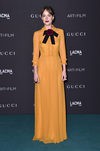 Dakota Johnson con vestido retro en color mostaza