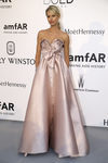 Karolina Kurkova con vestido largo de corte princesa sin mangas en tono neutro y maxi lazo