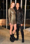Anna Ewer junto a Alexander Wang con mini vestido ajustado en dorado y botas militares negras