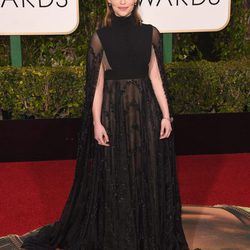 Emilia Clarke con vestido largo negro con transparencias y capa de Valentino 