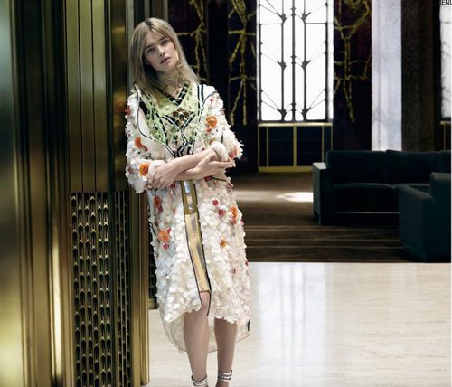 Natalia Vodianova con abrigo 3/4 blanco con detalles bordados de Prada