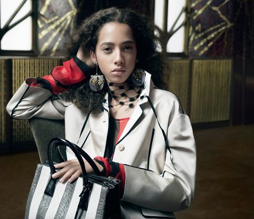 Yasmin Wijnaldum abrigo blanco y bolso mediano de cuero de Prada