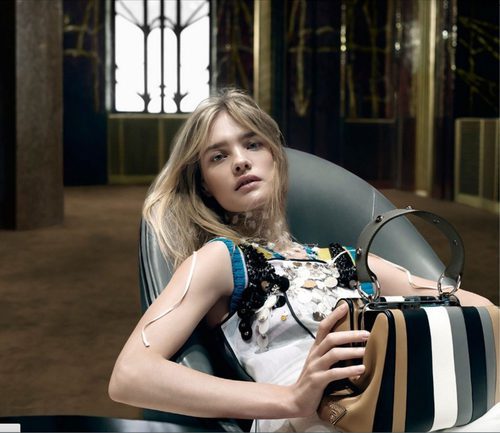 Natalia Vodianova con vestido blanco con detalles y bolso de Prada