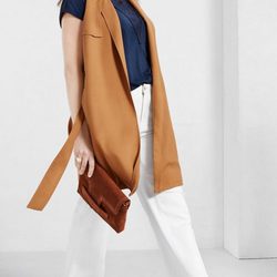 Chaleco largo de ante camel con pantalón blanco y bolso de mano de Violeta by Mango