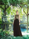 Vestido negro con motivos vegetales dorados en el cuerpo y falda plisada de vuelo de Carla Ruiz