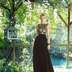 Vestido negro con motivos vegetales dorados en el cuerpo y falda plisada de vuelo de Carla Ruiz