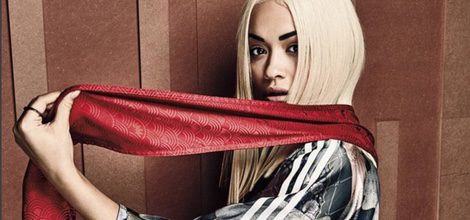 Rita Ora con ropa deportiva posando con el cartel de la nueva campaña para Adidas