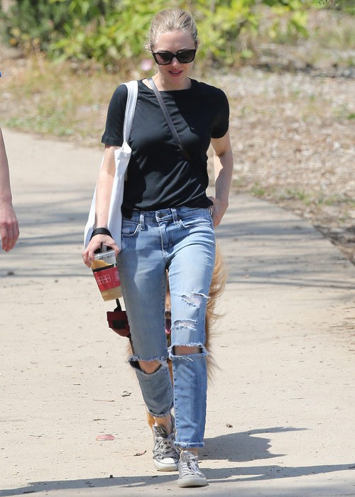 Amanda Seyfried con vaqueros rotos, básica negra y converse