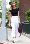 Karlie Kloss con pantalón blanco básica negra y tenis