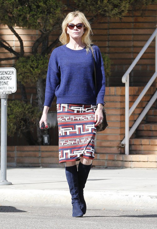 Melanie Griffith con jersey, falda pitillo y botas altas