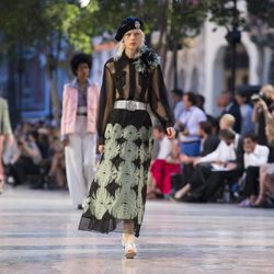 Modelo con camisa con transparencias y falda larga print de Chanel en el desfile Crucero 2017