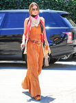 Alessandra Ambrosio con un vestido largo naranja y un pañuelo