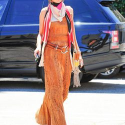 Alessandra Ambrosio con un vestido largo naranja y un pañuelo