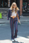 Gigi Hadid con un conjunto de pantalón y chaqueta a rayas estilo ochentero