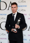 Raf Simons posando con un premio en la celebración de los CFDA Fashion Awards 2014