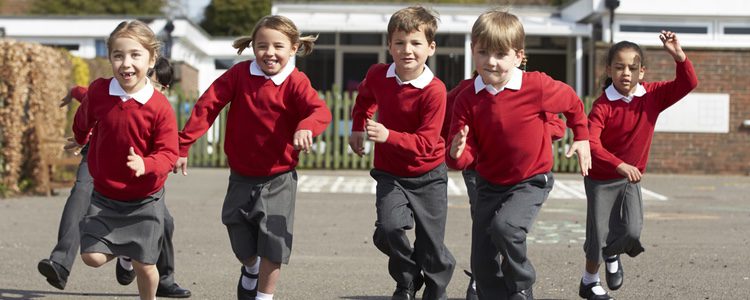 Niños de uniforme jugando en el cole