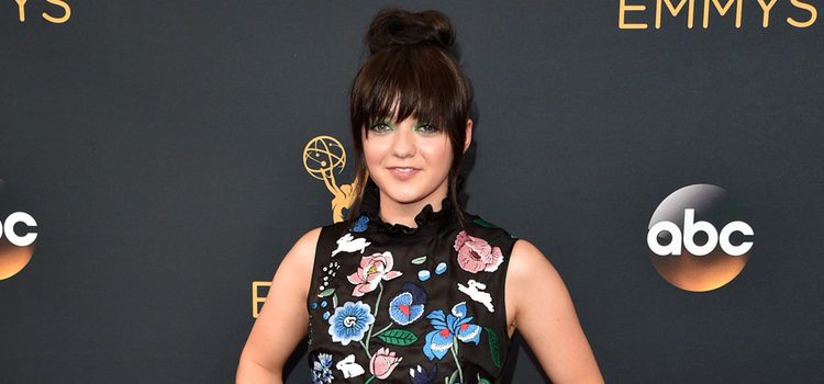 Maisie Williams con un vestido negro de flores en la alfombra roja de los Emmy 2016